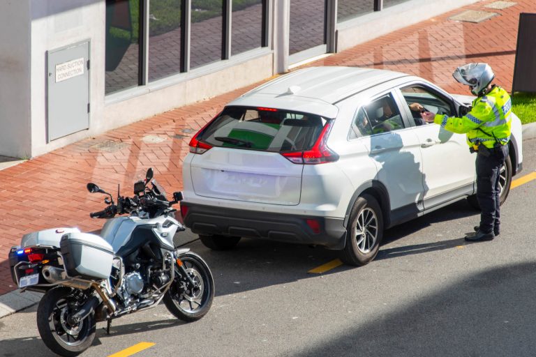 white car stopped by a police officer